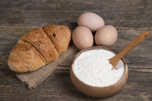 鸡肉新鲜的普通牛角面包 面粉和生鸡蛋放在木头表面高质量的照片美味面包房面包卷