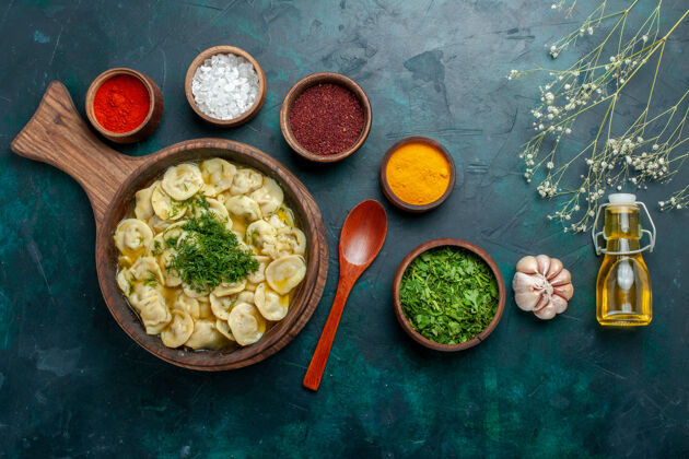 午餐俯瞰美味的饺子 不同的调味料放在深绿色的面上 食品配料产品面团 肉类蔬菜深绿色配料餐厅