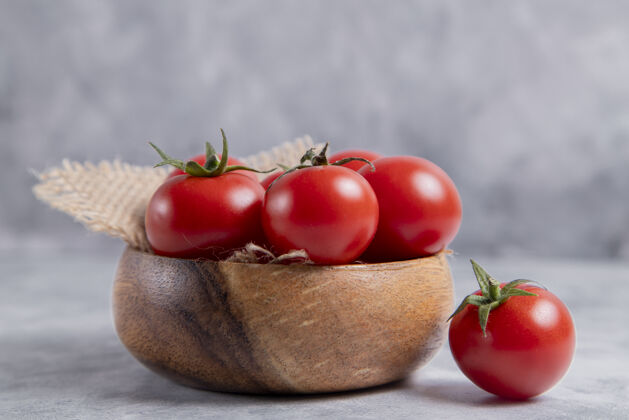 素食一个装满新鲜多汁的红色西红柿的木碗放在石桌上高质量的照片营养素食生的