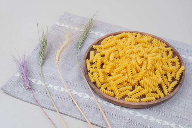 食品用五颜六色的小麦在桌布上放一盘生面食生的干的螺旋