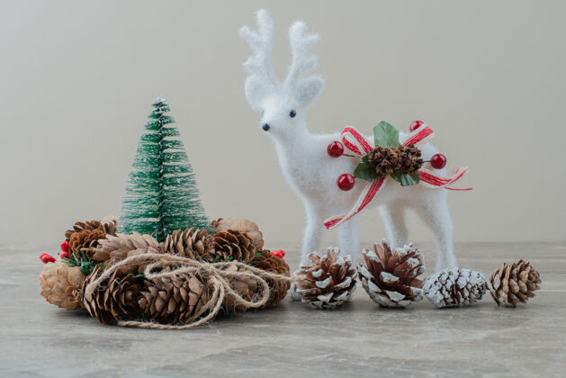 玩具松树 松果和玩具鹿放在大理石桌上节日装饰品圣诞节