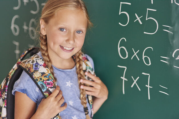 微笑学生在黑板旁边写着数字肖像积极的情绪女孩