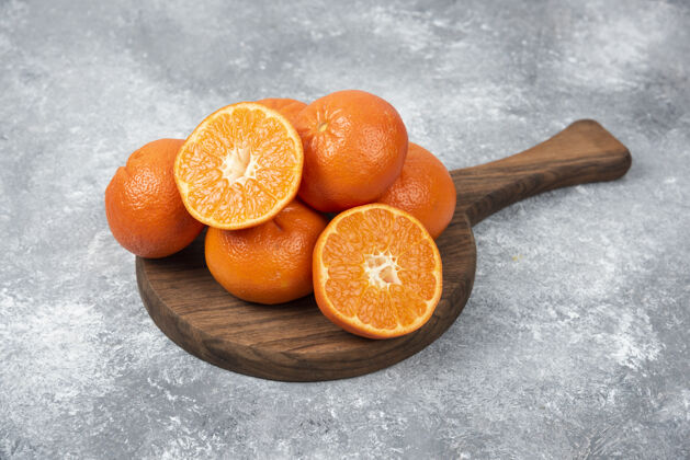 圆形石桌上摆满了橙汁水果的木板天然柑橘成熟