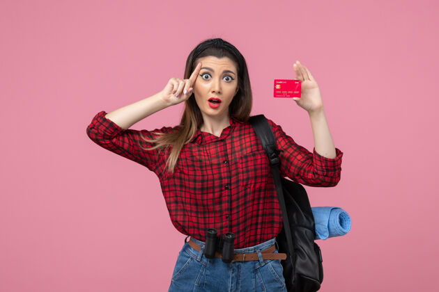 成人正面图：穿着红色衬衫的年轻女性 粉色背景上有银行卡的人类女性颜色黑发女士年轻女性
