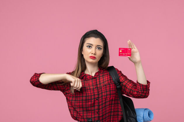 年轻女性正面图身穿红色衬衫的年轻女性 粉色背景上有银行卡 是人类女性的颜色人成人银行