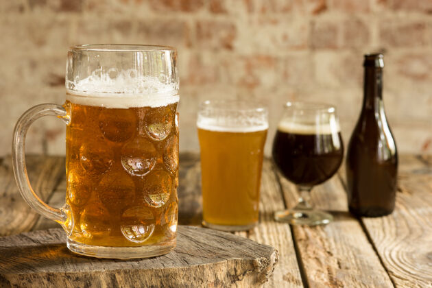 啤酒厂不同种类的黑啤酒和淡啤酒放在木桌上排成一行麦芽酒食物酒吧