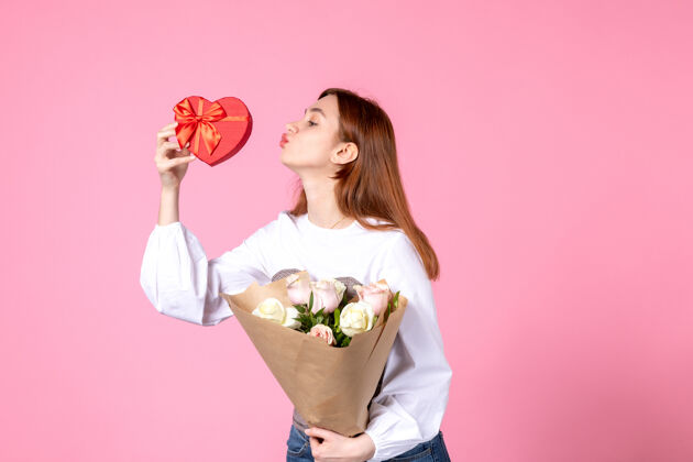 礼物正面图：年轻女性 带鲜花 在粉色背景上作为妇女节礼物 水平三月女性平等爱女性约会玫瑰花束玫瑰年轻女性