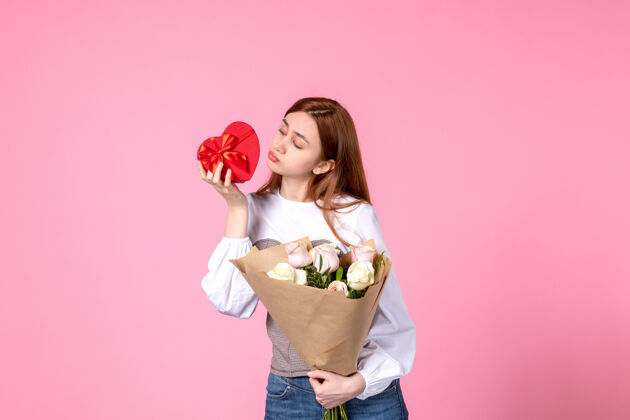 玫瑰正面视图：年轻女性 带鲜花 作为女性节礼物 粉色背景 水平三月平等 女性约会 玫瑰 爱情 性感礼物年轻女性礼物