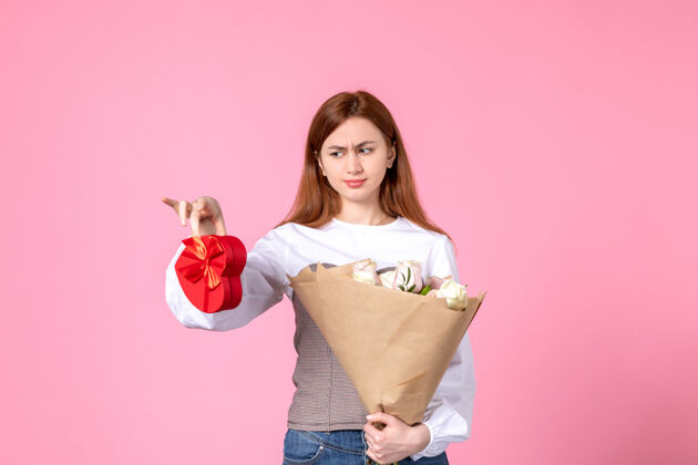 花束正面图：年轻女性 带鲜花 在粉色背景上作为妇女节礼物 水平三月平等 女性约会 玫瑰女人爱礼物玫瑰年轻女性