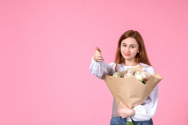玫瑰正面图：带花朵的年轻女性 作为女性节礼物 粉色背景 水平女性 三月日期 平等玫瑰 爱情 性感人年轻的女性花