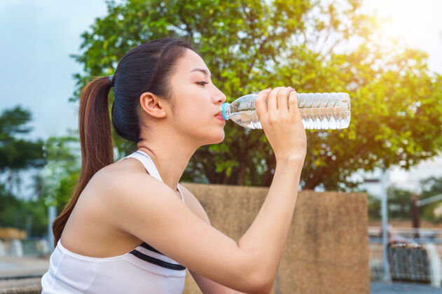 运动运动型年轻女子慢跑后喝水休息后有氧运动女性