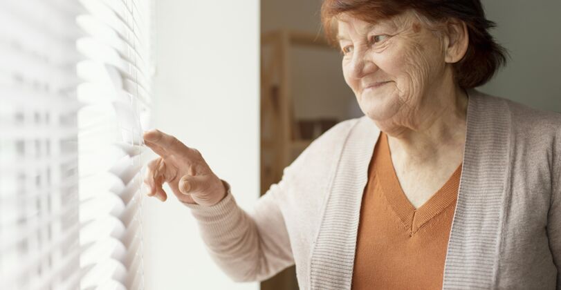 女人特写镜头女人看着窗外退休之家老年人生活方式