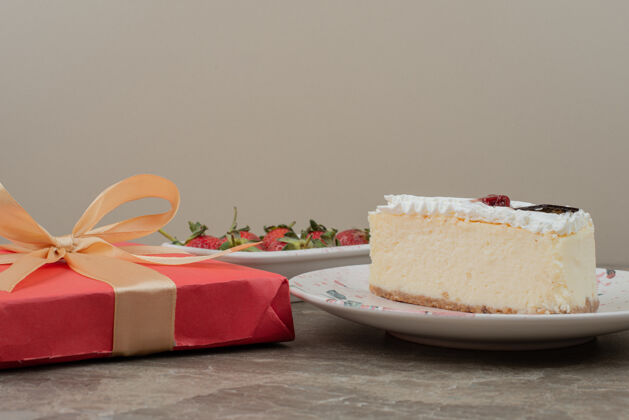 盘子芝士蛋糕 草莓和大理石桌上的礼品盒礼物冬天奶油