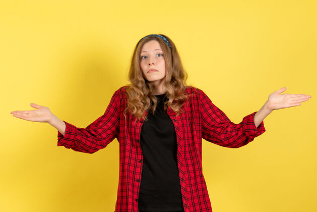成人正面图：穿着红色格子衬衫的年轻女性站在黄色背景上 摆姿势 女孩颜色 模特 人类女性站立衬衫人物
