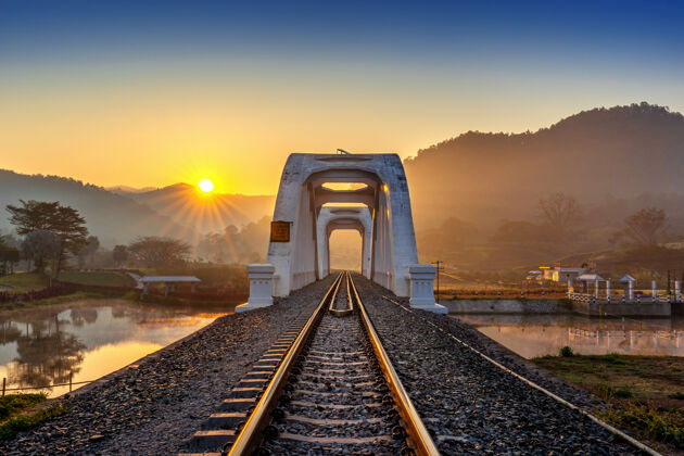 泰国泰国南丰日出时的塔孔布铁路桥或白桥通过顶部道路
