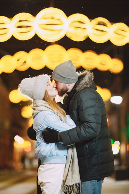 关系一对年轻夫妇在街上摆姿势的户外夜景照明庆祝日期