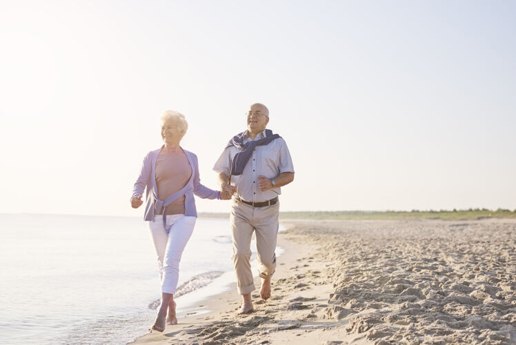 全长海滩上的老年人海滩上的老年夫妇 退休和暑假的概念祖父运动享受