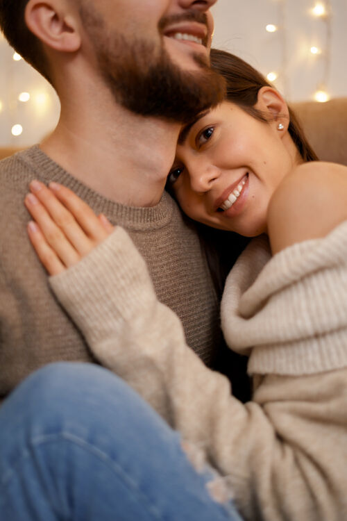 团结幸福的已婚年轻夫妇拥抱在一起 坐在舒适的沙发上新年享受关系