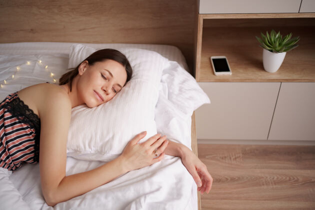 房子睡在床上的白种女人女人喜欢卧室里新鲜柔软的床上用品和床垫孤独枕头清新
