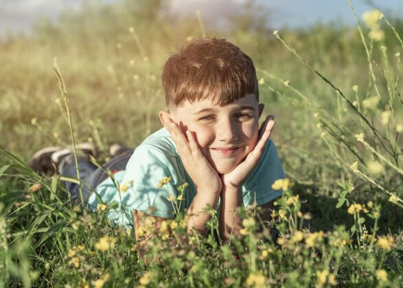 肖像坐在草地上的全垒打小子青春生活方式水平