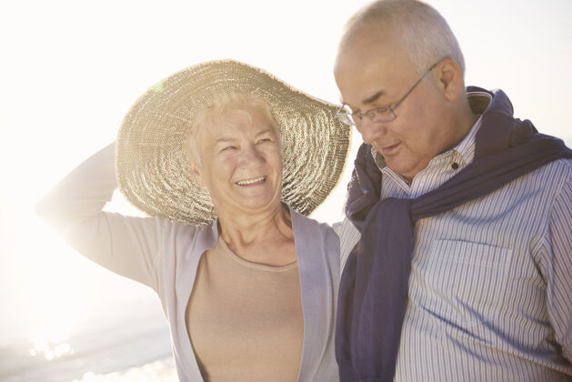 无忧无虑老年夫妇在沙滩 退休和暑假的概念情人老年人退休