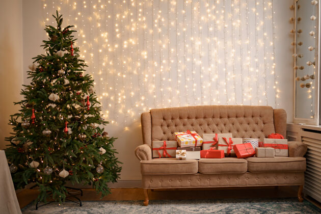 盒子在舒适的沙发和装饰过的圣诞树上摆放着许多礼物辉光礼物家具