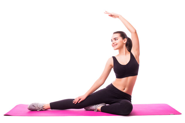 白色摄影棚拍摄的一个年轻的健康女子正在做瑜伽练习隔离在白色背景身体女孩伸展