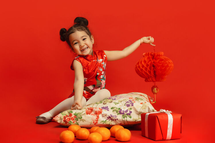 文化亚洲可爱的小女孩手提灯隔离在红墙在传统服装季节闪亮祝愿