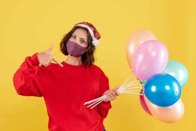 庆典黄色庆典派对上戴着面具手持气球的年轻女子气球颜色喜剧演员