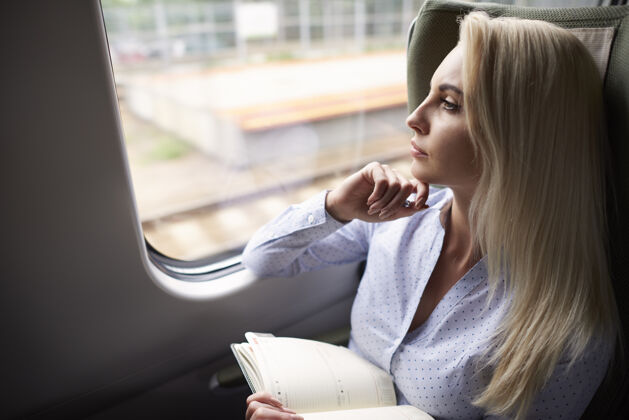 精益在火车上和组织者在一起的女人舒适金发乘客
