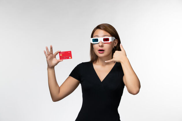 面部正面图年轻女性手持银行卡 戴着浅白色的太阳镜电影院美丽太阳镜
