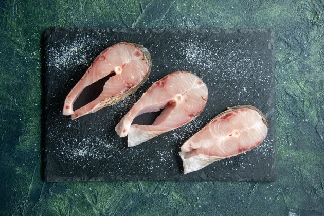 凉鞋顶视图深色餐桌上的新鲜鱼片海鲜海洋肉海洋餐食品沙拉水胡椒腹足动物餐海鲜