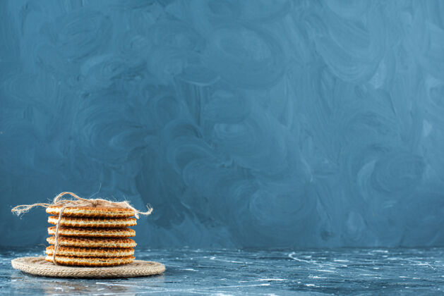 美味美味的华夫饼放在三角架上 蓝色背景美味糕点糖