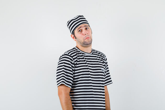 一个年轻的男性穿着t恤 戴着帽子 看着镜头 愁眉苦脸 前视姿势男性T恤