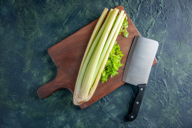 韭菜顶视图新鲜的绿色芹菜与大刀上深蓝色背景沙拉健康饮食食品餐彩色照片装订晚餐膳食