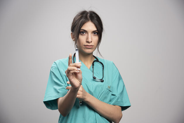 听诊器女医生拿着注射器在格雷身上工作个人肖像