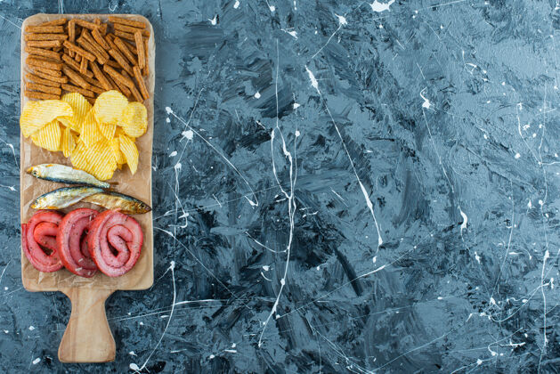 美味猪油 鱼 薯条和面包屑放在砧板上 蓝色背景美味脆好吃
