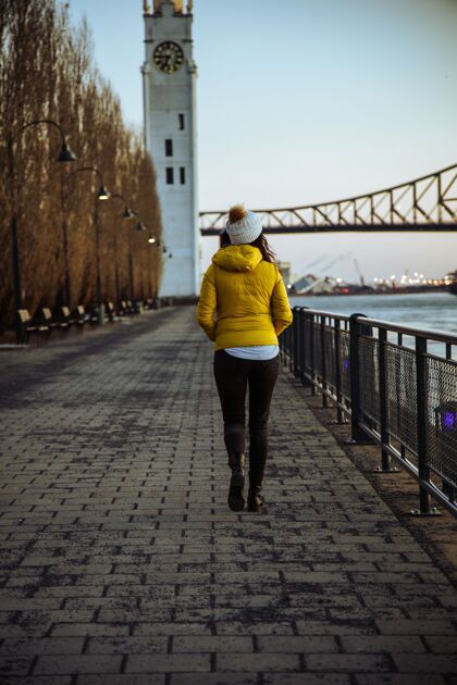 帽子在加拿大雅克卡地亚桥附近的公园散步的女人河流充满活力地标