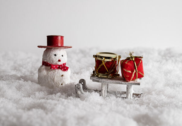 特写可爱的雪人玩具 雪橇 和五颜六色的礼品盒在雪地里玩具快乐心情