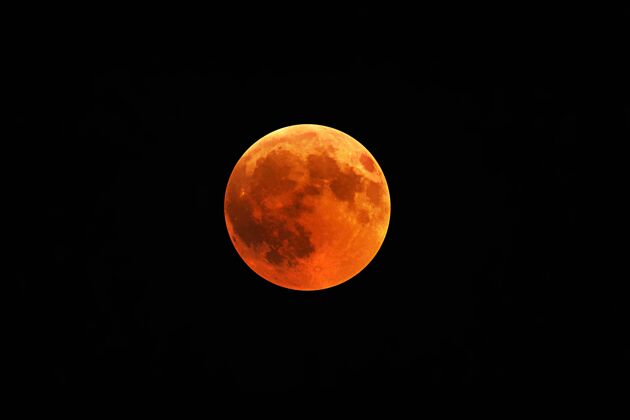 辉光一轮红月与一片漆黑夜空的美丽镜头轨道表面宇宙