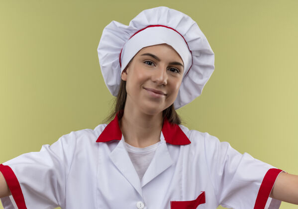 复制年轻快乐的白人厨师女孩身着厨师制服 张开双臂 孤立地站在有复制空间的绿地上空间请厨师