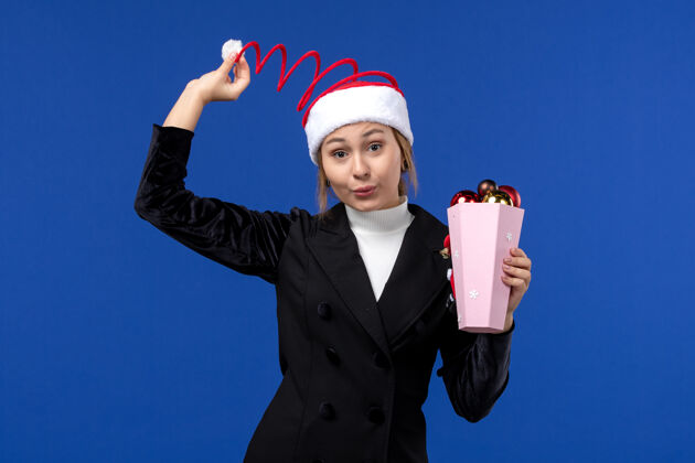套装前视图年轻女性与树玩具上的蓝色墙壁情感新年假期玩具圣诞节工人情感