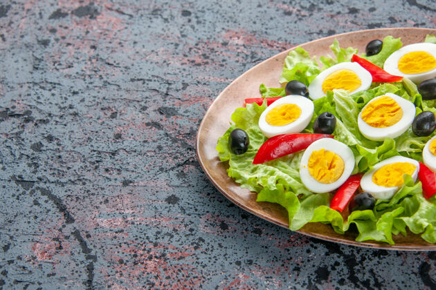 开胃菜正面是美味的鸡蛋沙拉 背景是绿色沙拉和橄榄前面早餐绿色