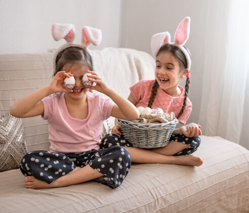 摆姿势快乐的小姐妹们抱着一篮复活节彩蛋摆姿势女孩复活节兔子