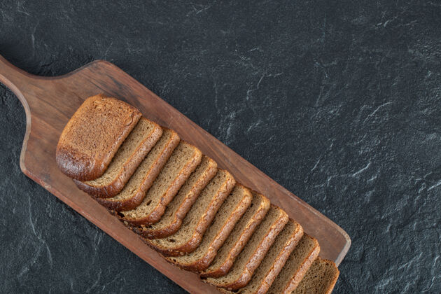 面包有面包片的木制砧板餐吃俯视图