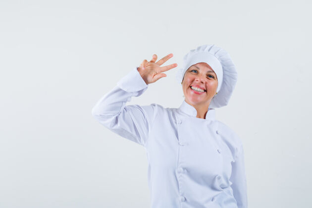 女性一位身穿白色制服的女厨师 脸上挂着v字 看上去很开朗厨师卷发外观