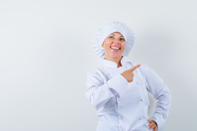 欢呼穿着白色制服的女厨师指着右上角 看上去很高兴女性女人休闲