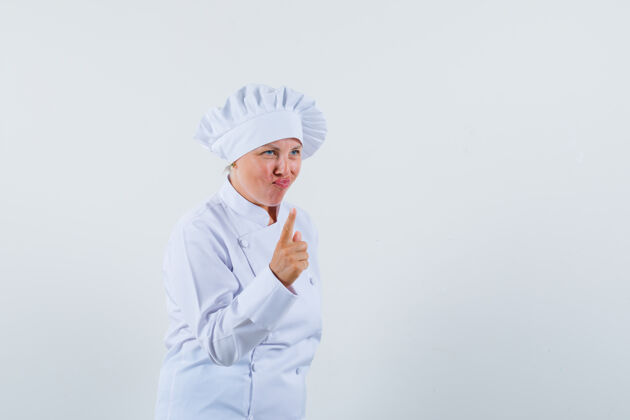 化妆身着白色制服的女厨师 展示警告手势 看上去很专注魅力女人女士