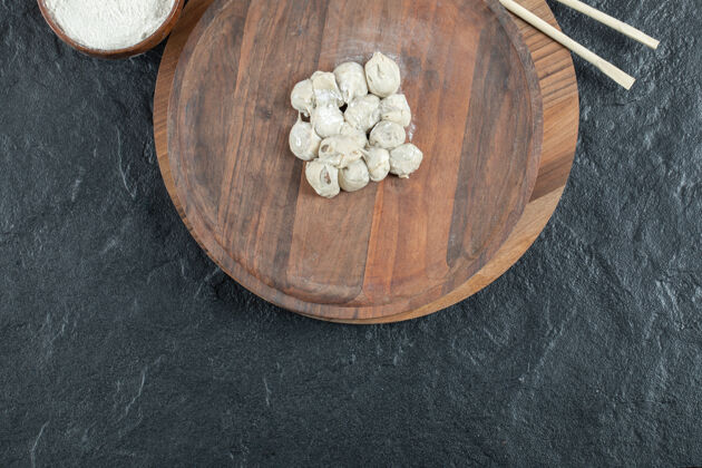 小吃一块用生饺子和面粉做成的木制圆板冷冻加工自制