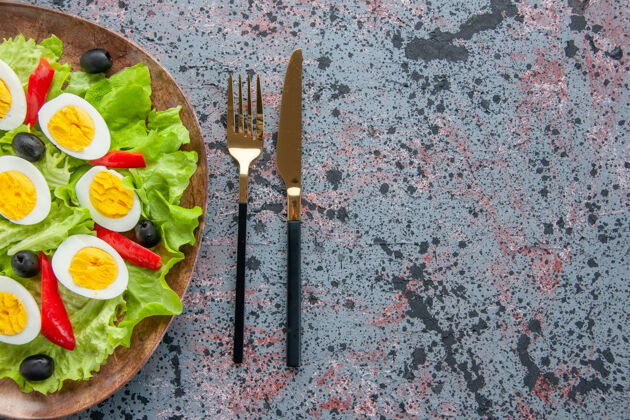 橄榄顶视图美味的鸡蛋沙拉与绿色沙拉和橄榄在轻背景饮食早餐刷子